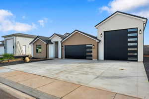 View of front of house with an attached garage, concrete driveway, stucco siding, brick siding, and a tiled roof