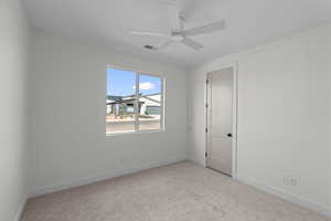 Empty room with light carpet and ceiling fan