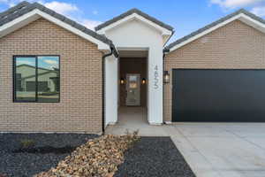 Ranch-style home with driveway, brick siding, and a garage