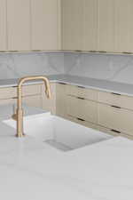 Kitchen with cream cabinetry and light stone counters