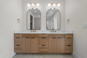 Bathroom with double vanity, recessed lighting, and light tile patterned floors