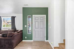 Foyer featuring light wood-style flooring and stairway