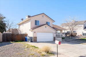 View of front of property featuring concrete driveway, stucco siding, and brick siding