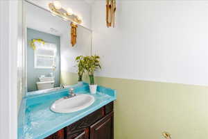 Half bathroom with vanity and toilet