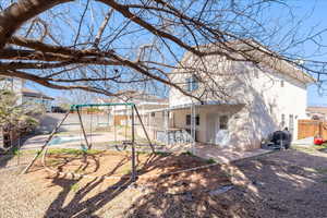 Back of house featuring a fenced backyard, stucco siding, a patio, and a playground