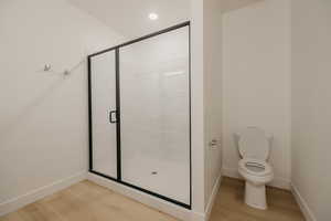 Bathroom featuring a shower stall, light wood-type flooring, and recessed lighting