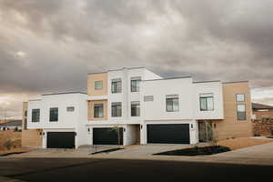 Contemporary house with stucco siding, driveway, and a garage