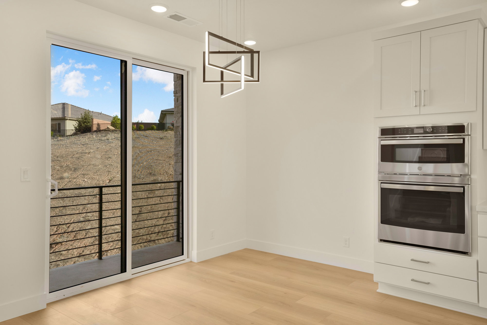 Sliding glass door opening to an outdoor area with horizontal metal railings
