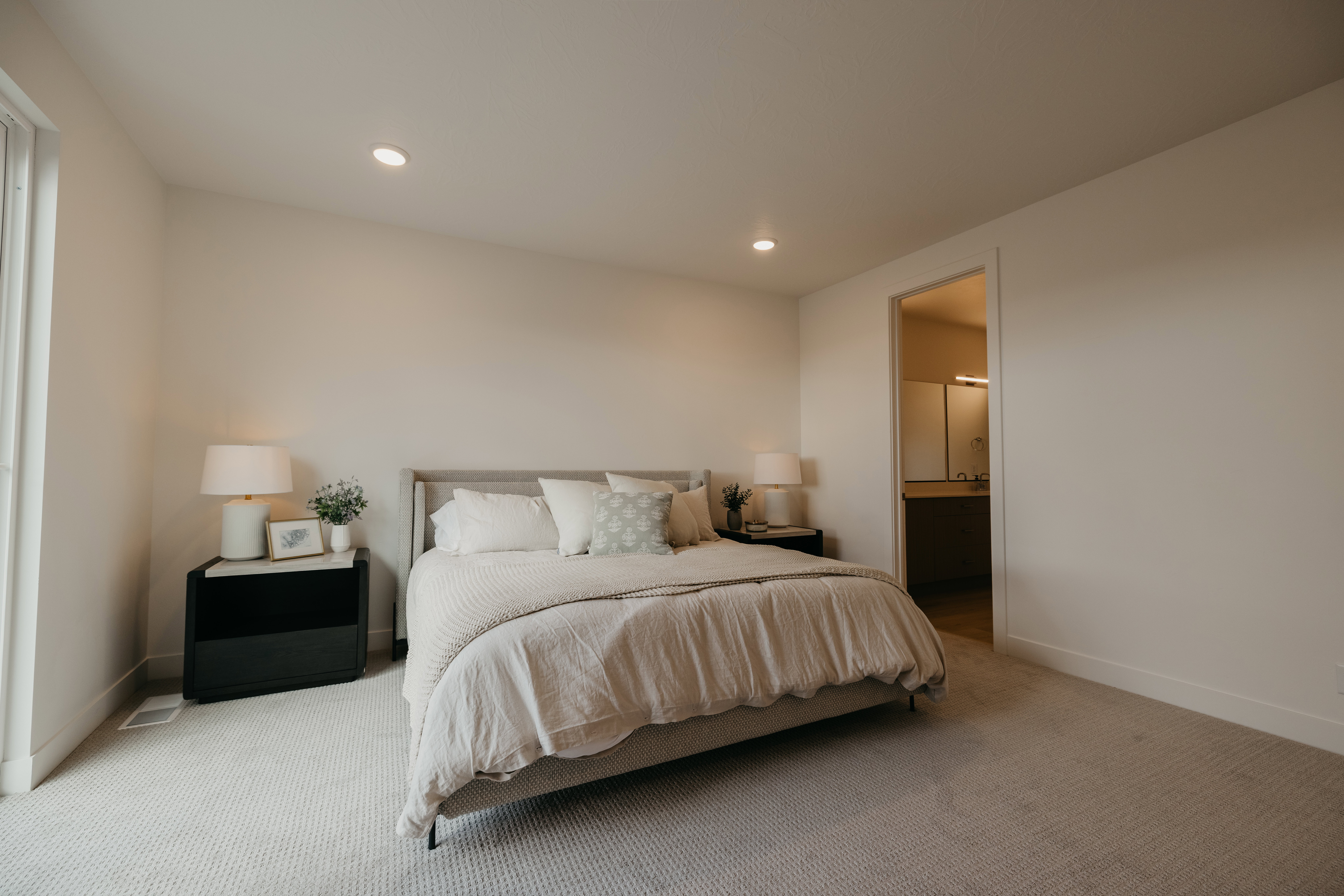 Carpeted bedroom with recessed lighting and ensuite bath