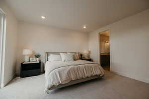 Carpeted bedroom with recessed lighting and ensuite bath