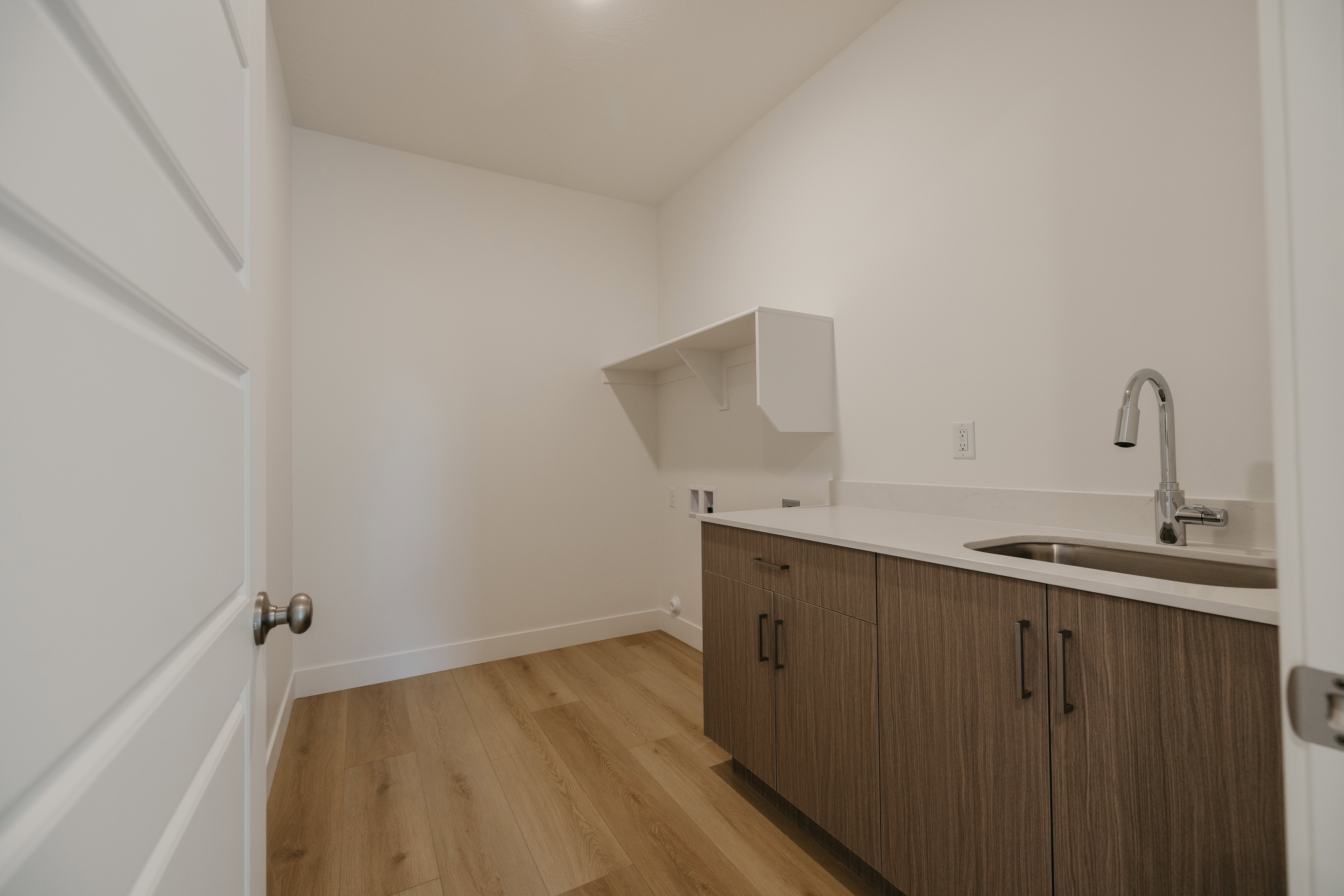 Laundry room featuring light wood-style floors, cabinet space, and washer hookup