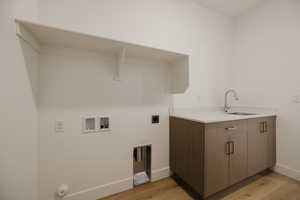 Laundry area featuring light wood-style floors, washer hookup, electric dryer hookup, and cabinet space