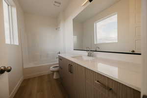 Bathroom featuring vanity, bathing tub / shower combination, light wood-style flooring, and plenty of natural light