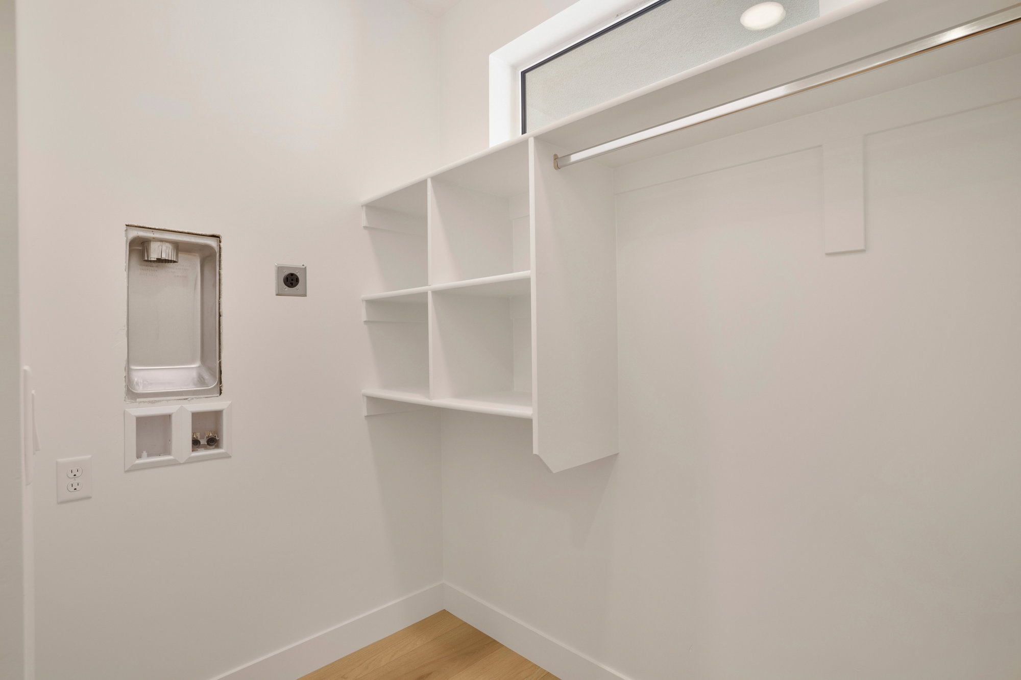 Dedicated laundry area featuring a washer hookup, dryer vent, and light wood-finish flooring
