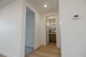 Hallway with light wood-style floors and baseboards