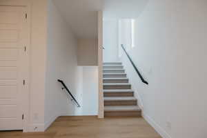 Stairway featuring wood finished floors and baseboards
