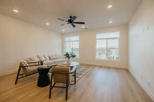Living area with light wood-type flooring, ceiling fan, and recessed lighting