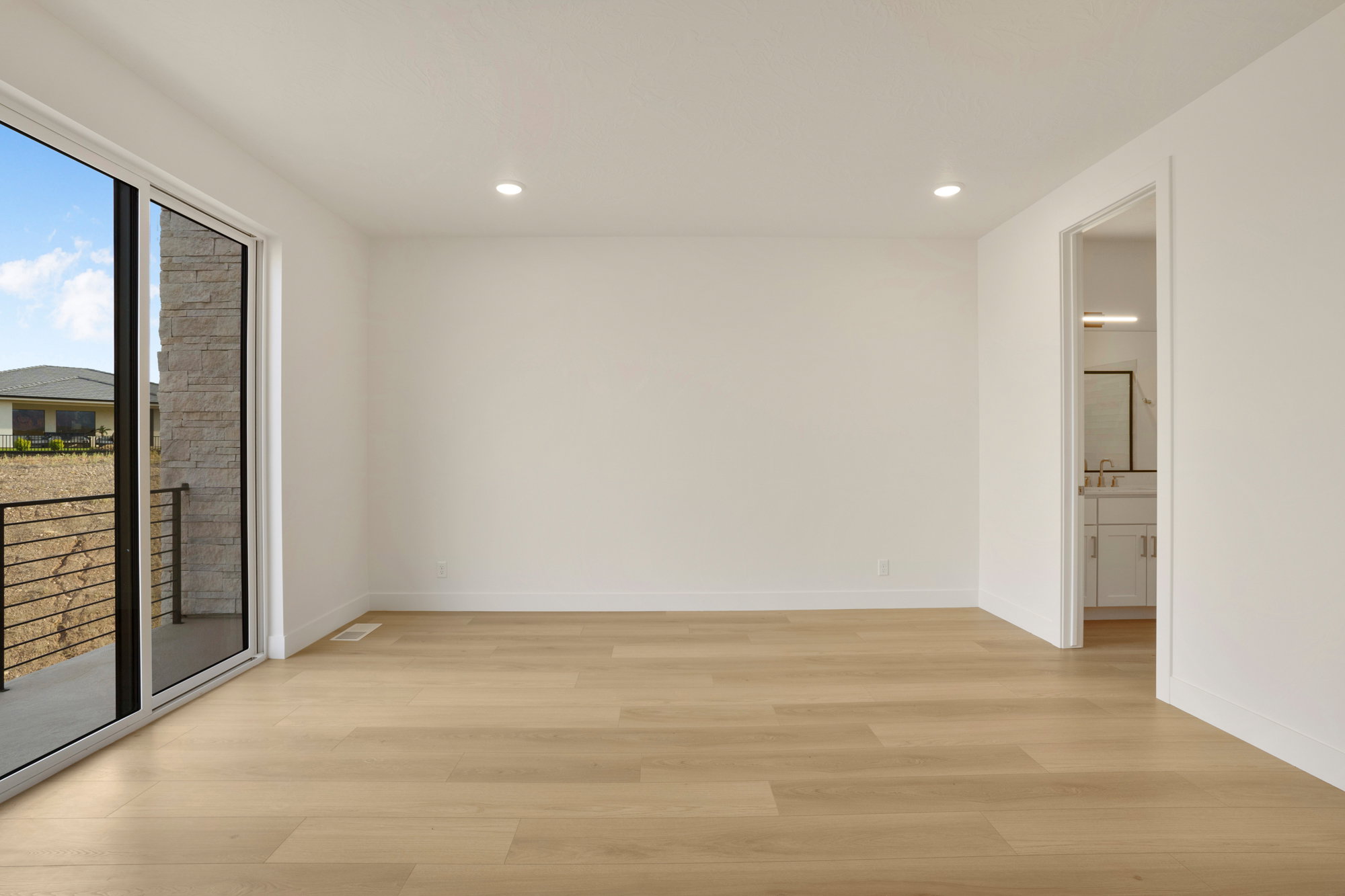 Spacious interior featuring light wood-finish flooring, recessed lighting, and white baseboards