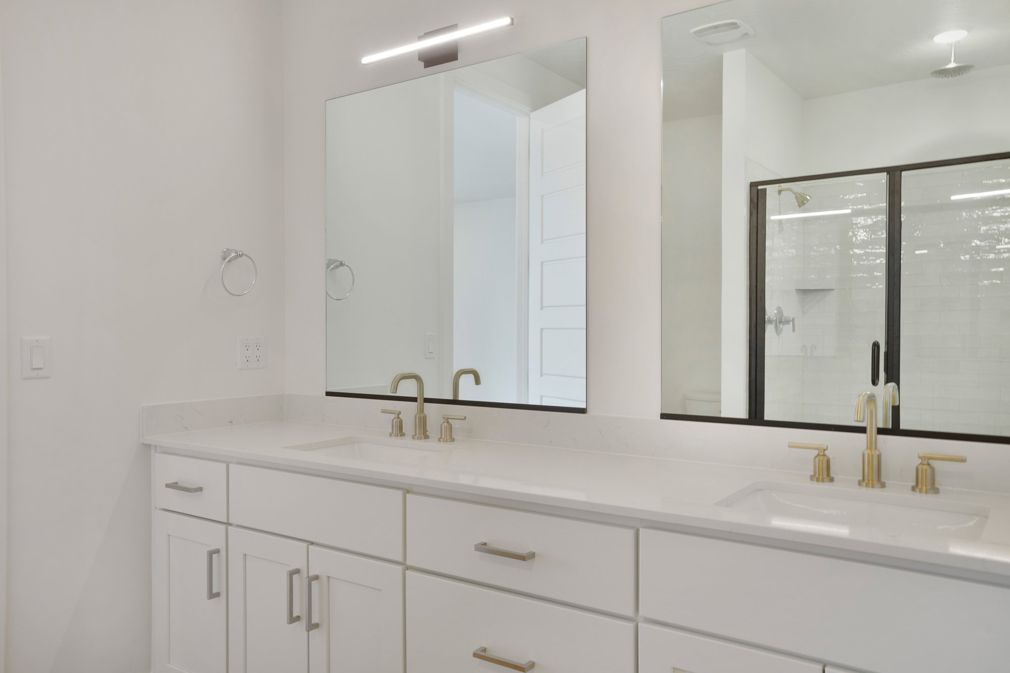 Dual vanity with white cabinetry, light-toned countertops, and two rectangular undermount sinks