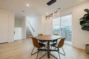 Dining room featuring light wood-style flooring, stairs, and recessed lighting