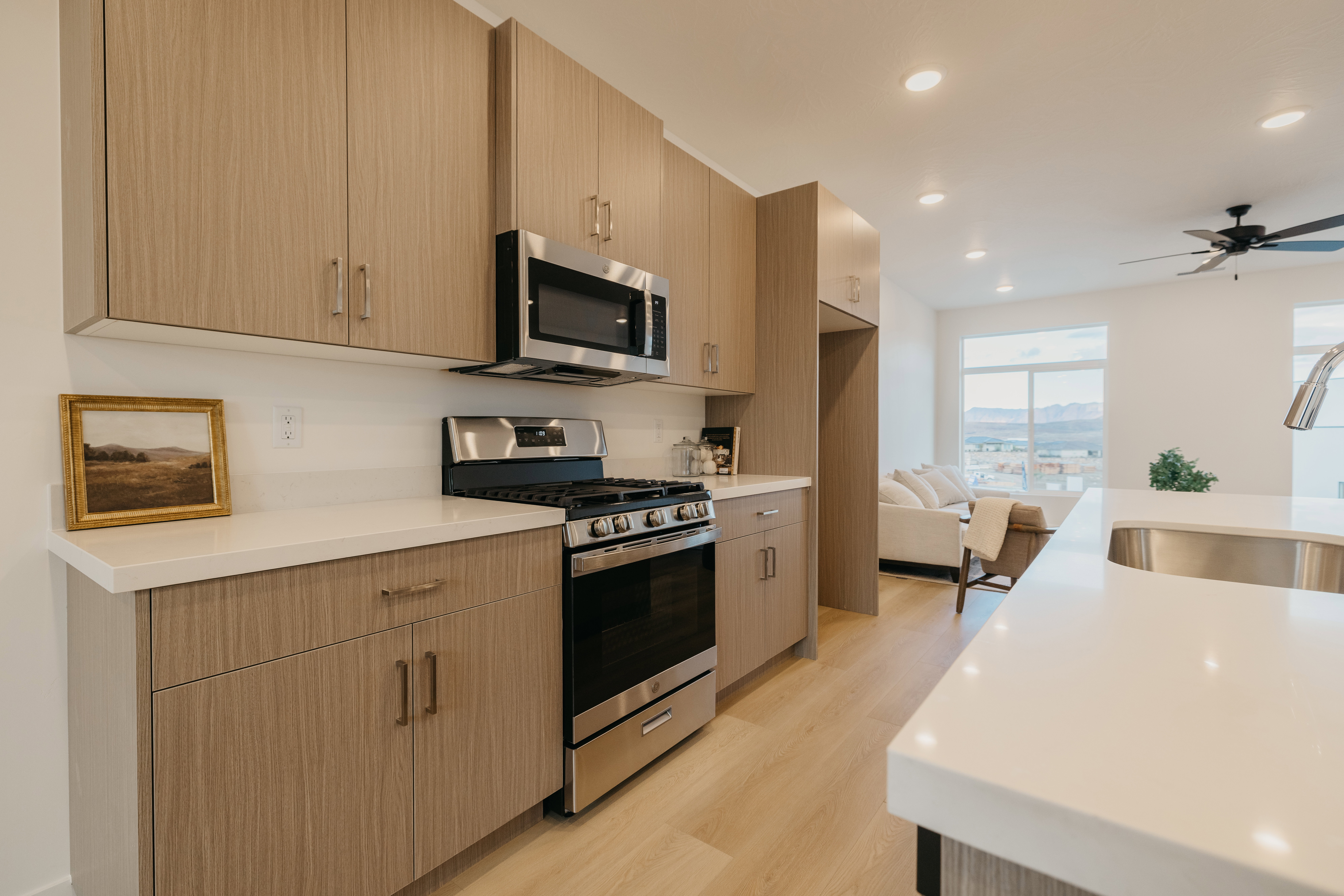 Kitchen featuring stainless steel appliances, light wood-type flooring, recessed lighting, modern cabinets, and light stone countertops