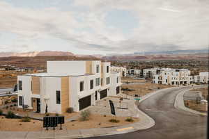 View of property featuring driveway, an attached garage, a mountain view, and a residential view