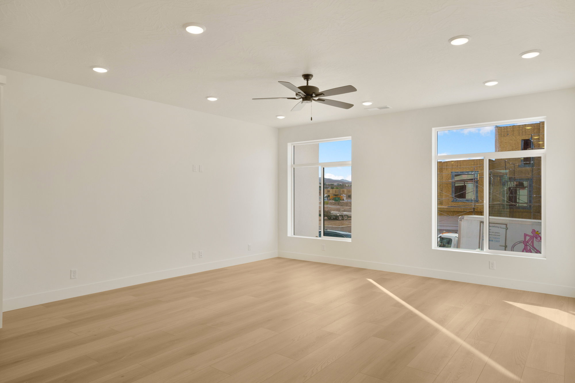Expansive interior space featuring light wood-finish flooring and recessed lighting