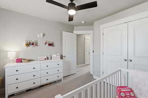 Bedroom featuring light carpet, a closet, and ceiling fan