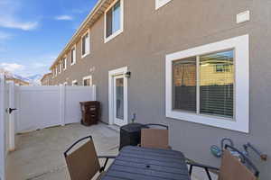 View of patio with a mountain view, a gate, and outdoor dining space
