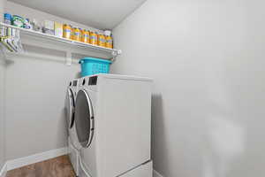 Laundry room with washing machine and dryer and wood finished floors