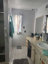 Full bath featuring vanity and light tile patterned floors