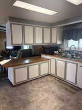 Kitchen with white cabinets, black microwave, and decorative backsplash