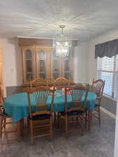 Dining area featuring a chandelier and a textured ceiling