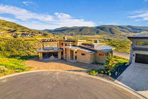 Property under construction with a mountain view and driveway