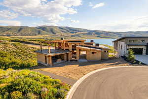 View of front of home with a water and mountain view and stone siding