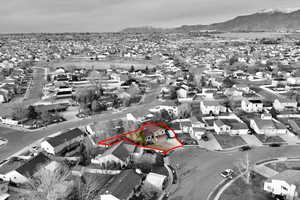 Aerial perspective of suburban area with property parcel outlined and a mountain backdrop
