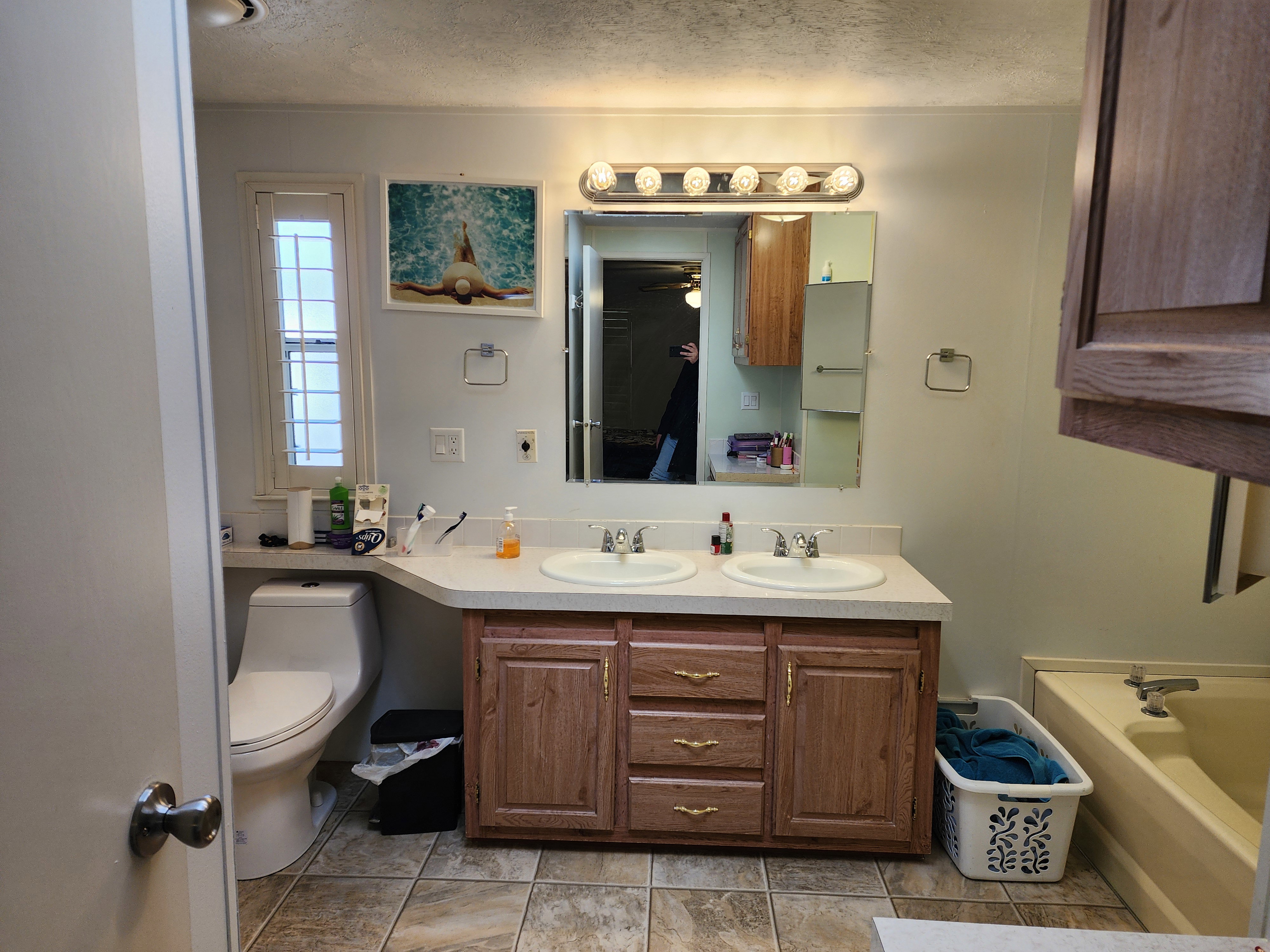 Full bath with double vanity, a bath, and a textured ceiling