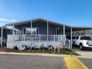 Manufactured / mobile home featuring a large porch and a carport