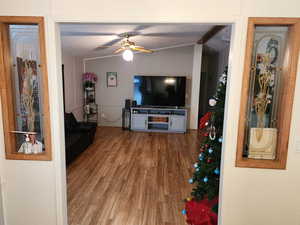 Living area featuring wood finished floors, vaulted ceiling, and ceiling fan