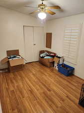Unfurnished bedroom with light wood-style floors, ceiling fan, and a closet