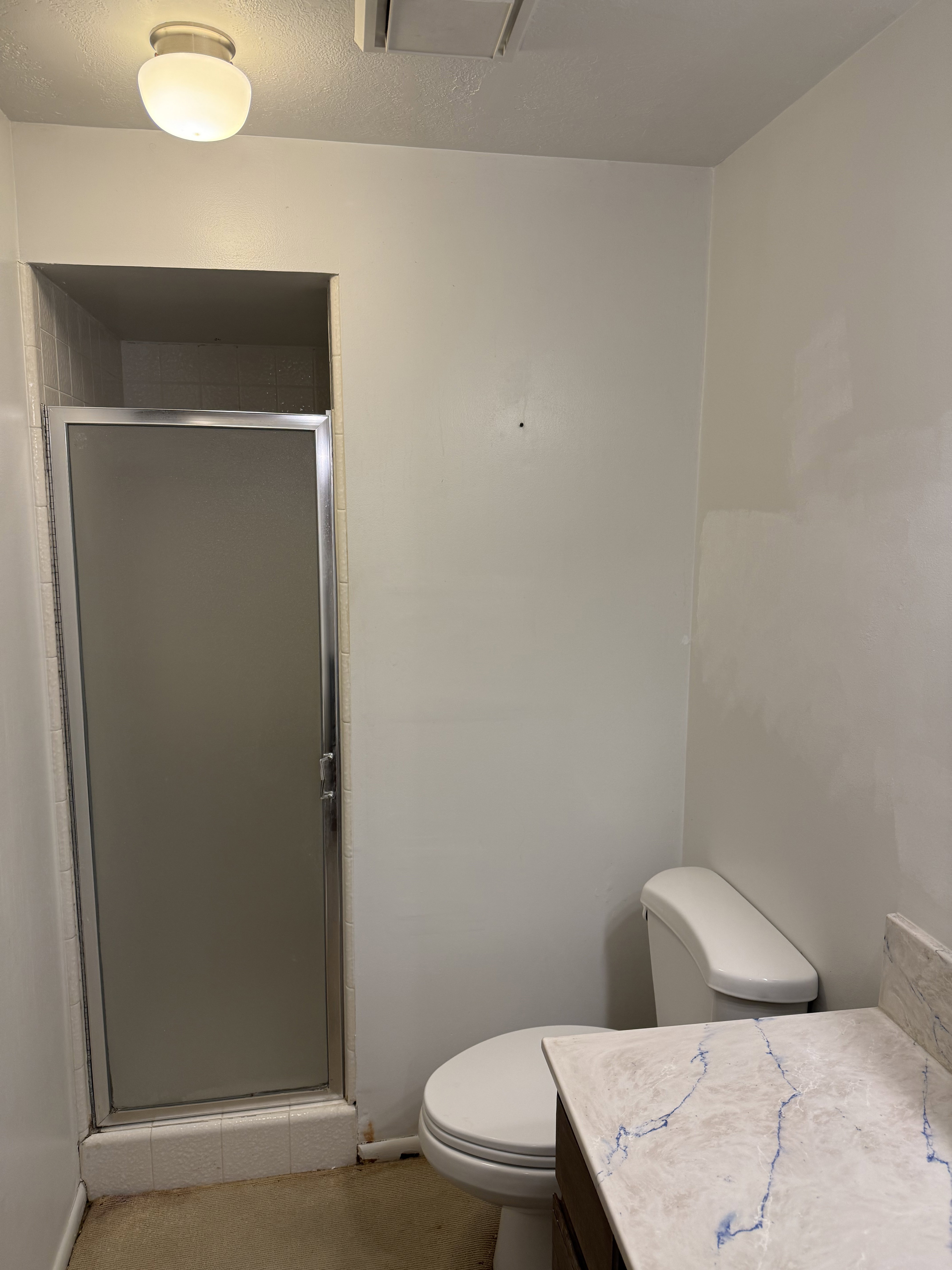 Bathroom with a shower, and a textured ceiling