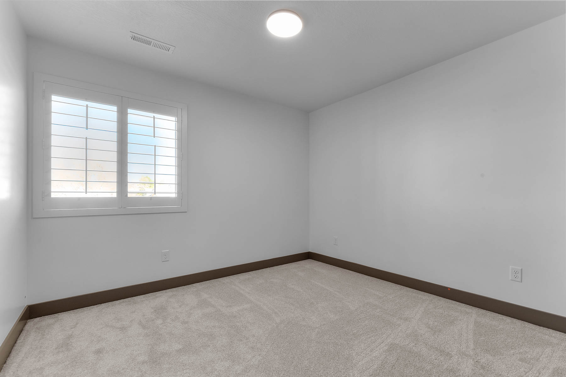 Carpeted spare room with baseboards