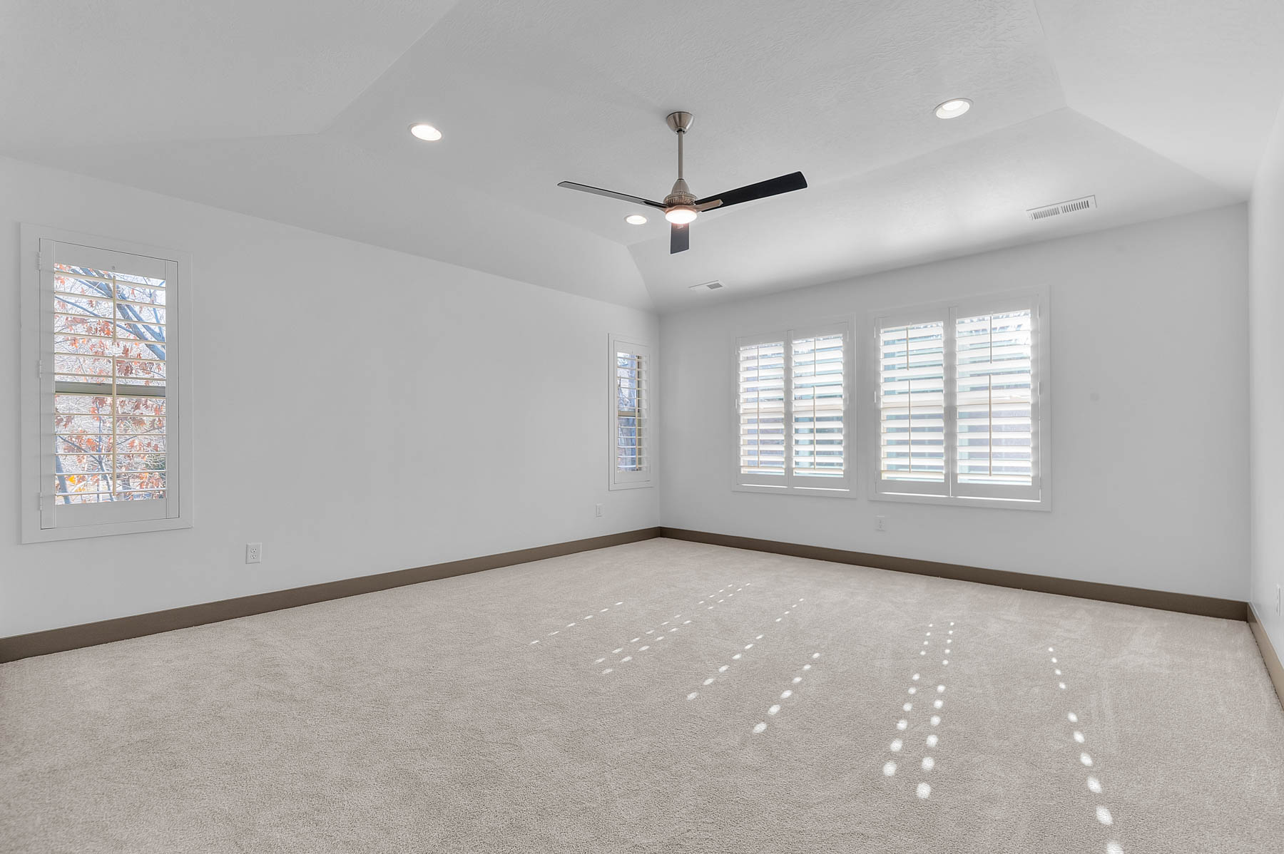 Carpeted empty room featuring recessed lighting, a ceiling fan, and vaulted ceiling