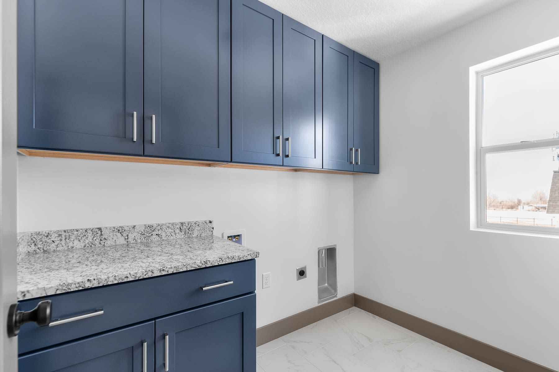 Laundry room with washer hookup, electric dryer hookup, cabinet space, and light marble finish floors