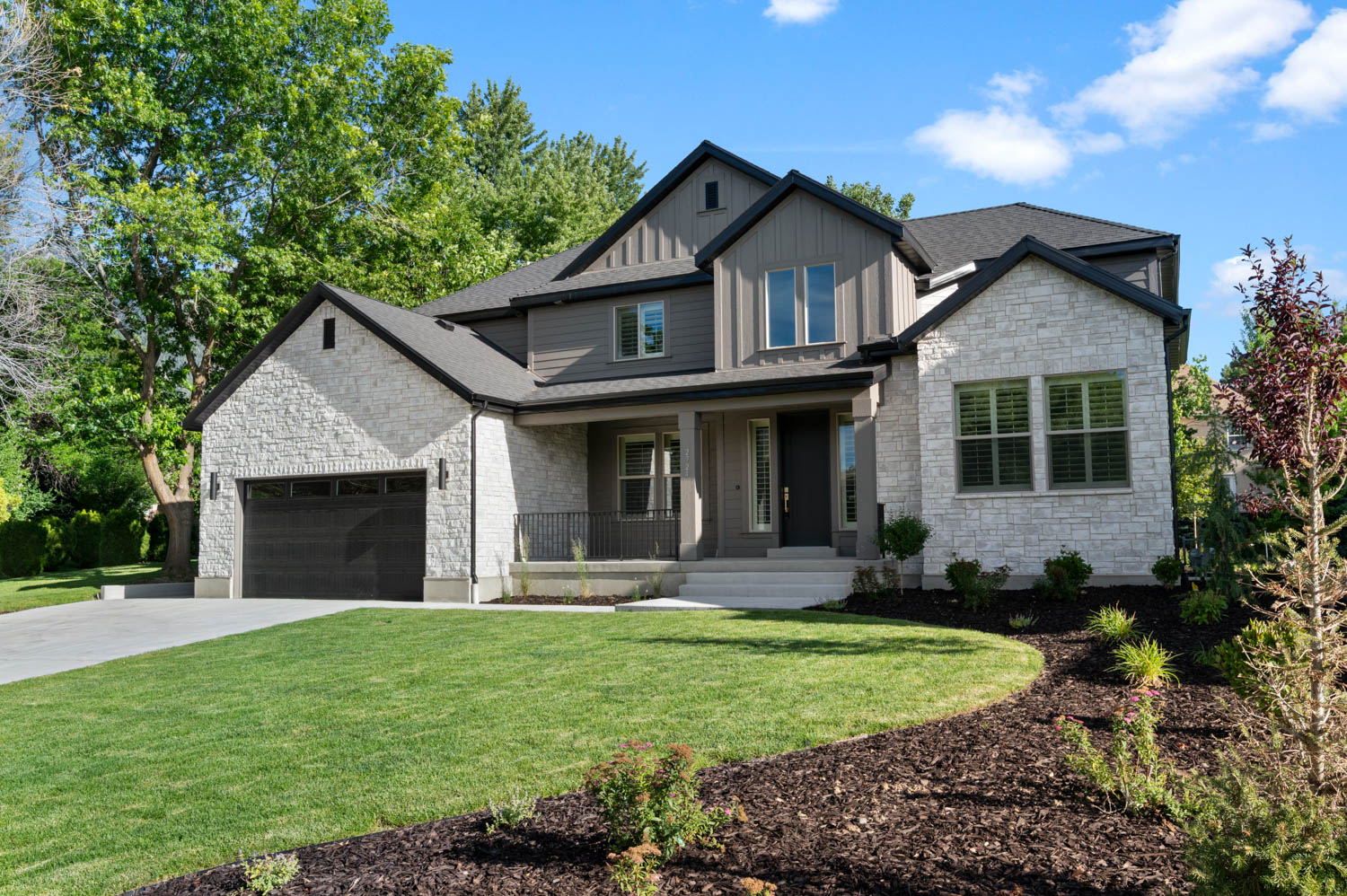 Contemporary two-story residence featuring a stone and board-and-batten exterior