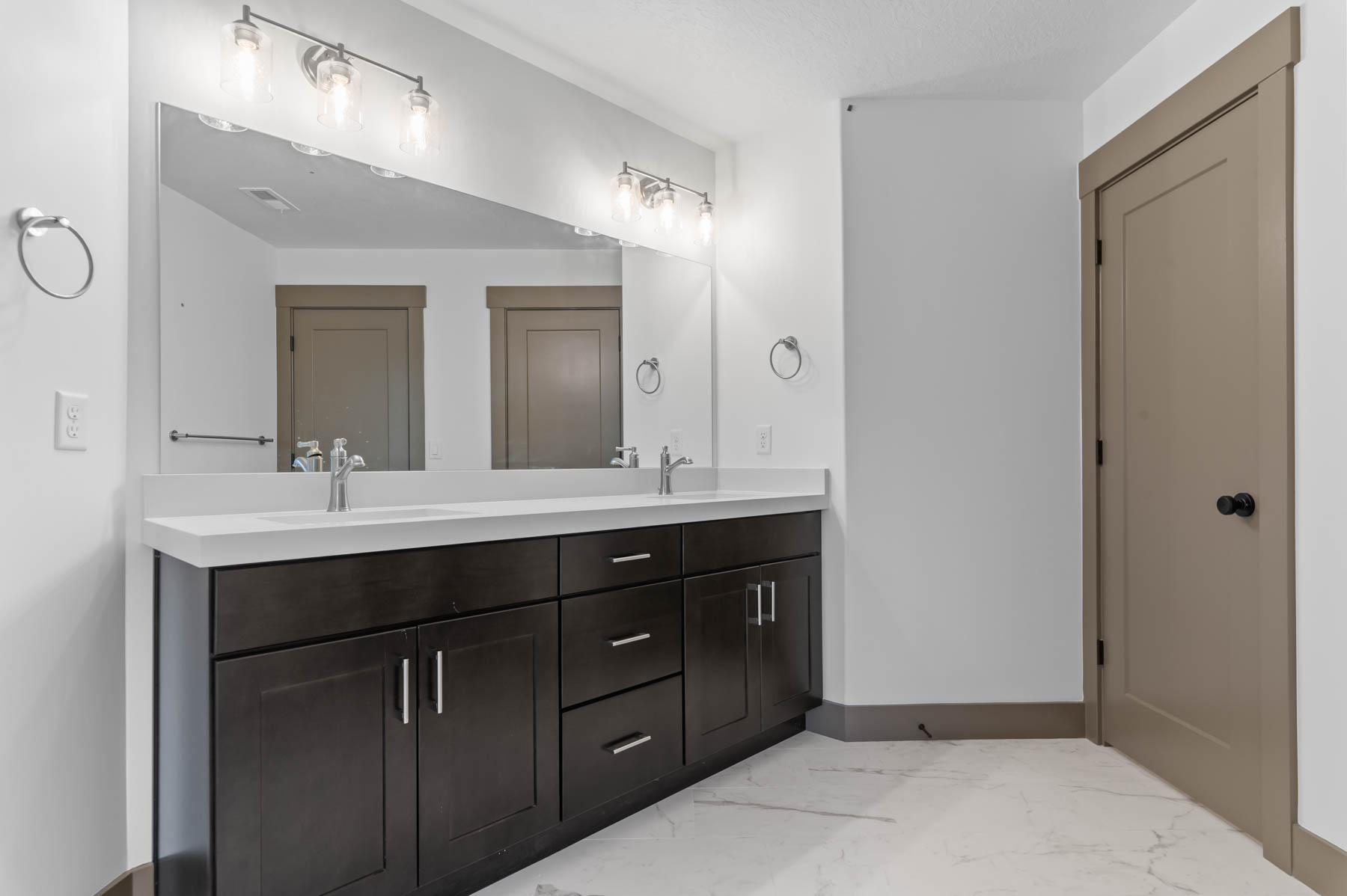 Bathroom featuring double vanity and light marble finish floors