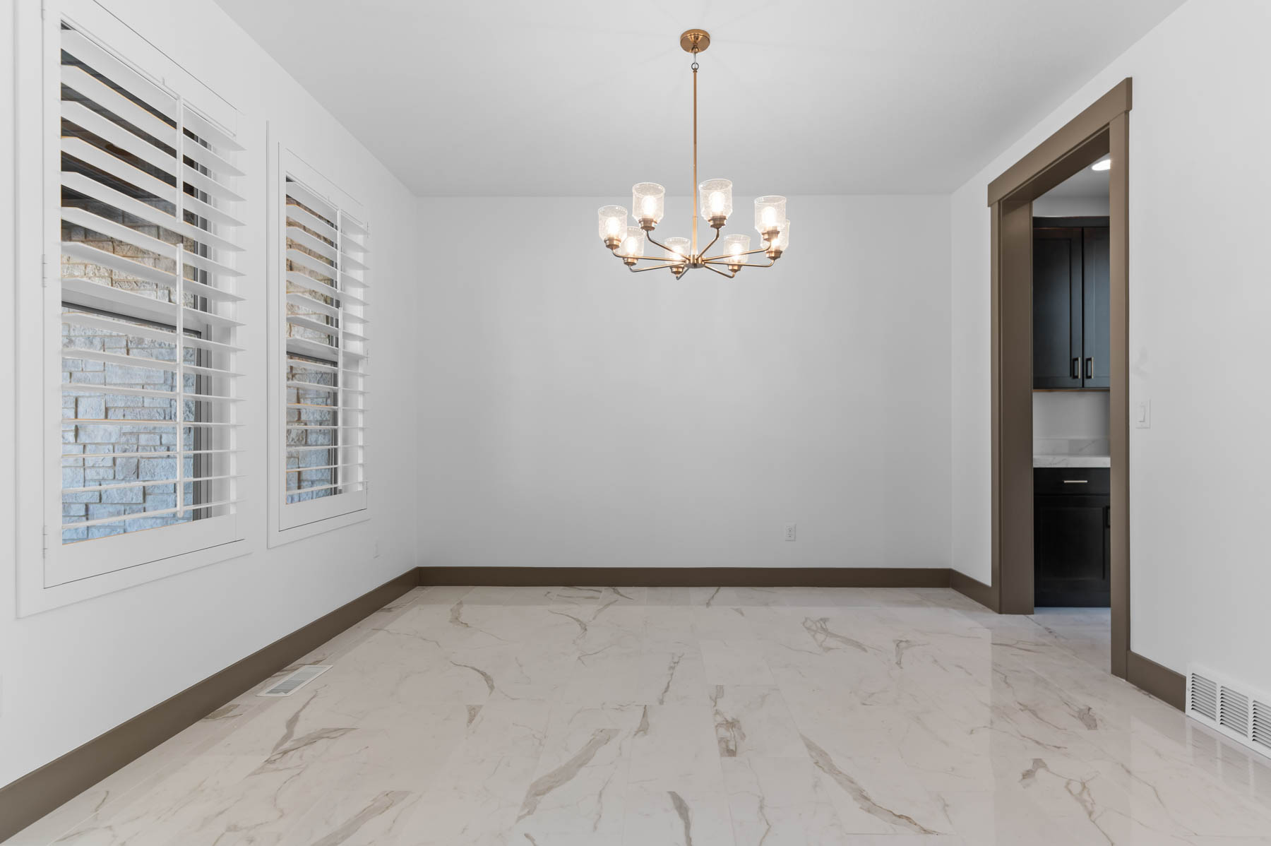 Unfurnished room with hanging lights and light marble finish flooring