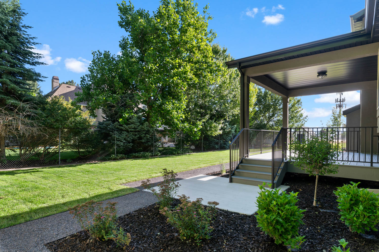 Covered porch featuring exterior lighting and dark metal railings