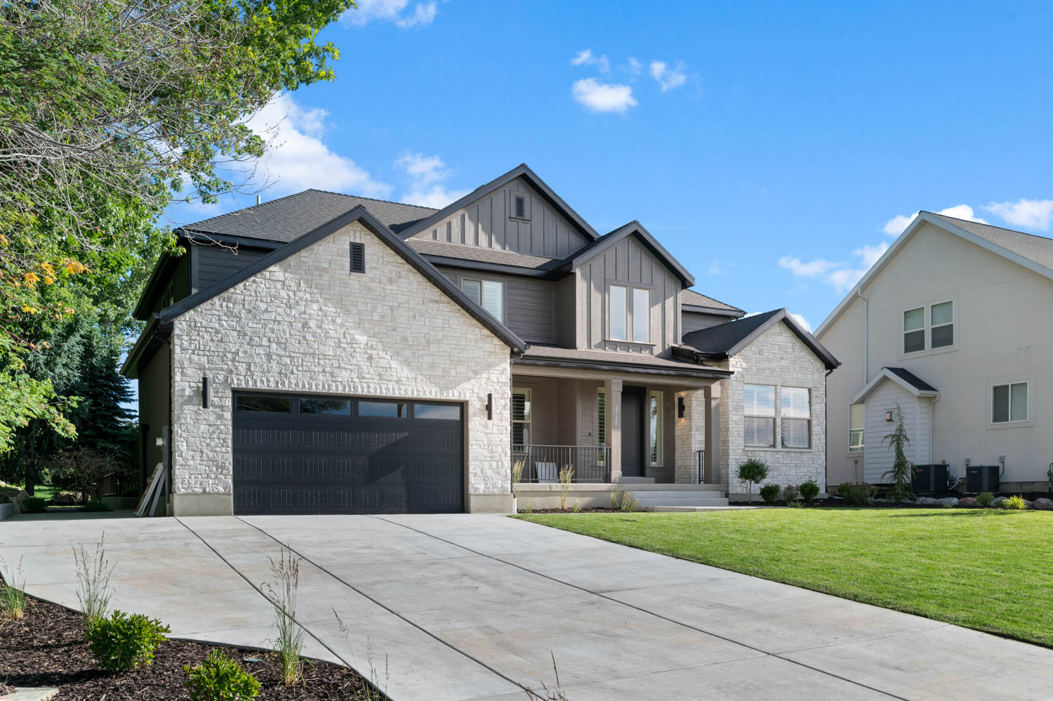 Contemporary exterior featuring a combination of light-toned stone veneer and dark vertical siding