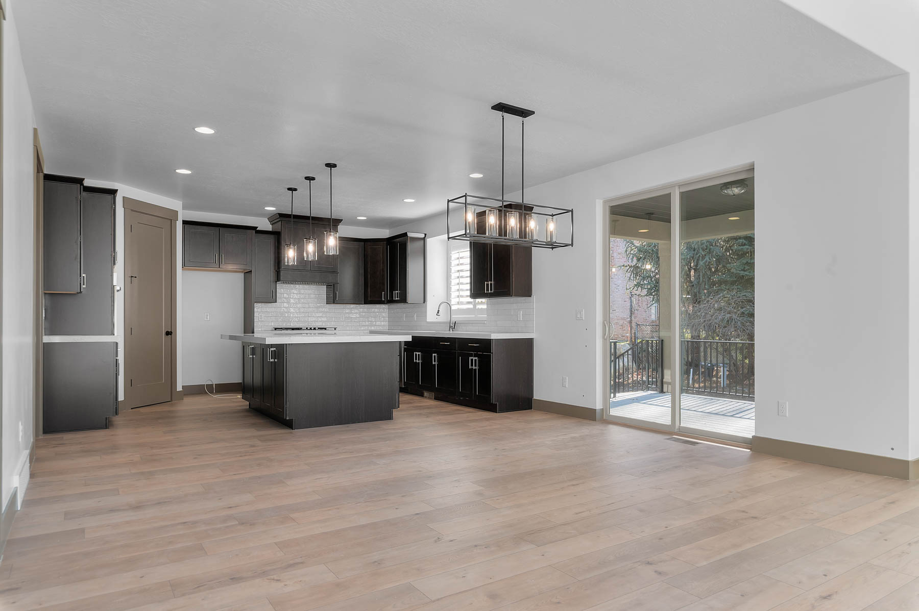 Kitchen featuring a center island, tasteful backsplash, light wood-style flooring, and hanging lights
